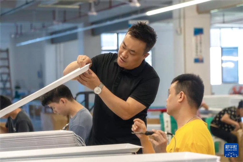 工业设计师马驰（左）和同事在工作室中研究产品（资料照片）。