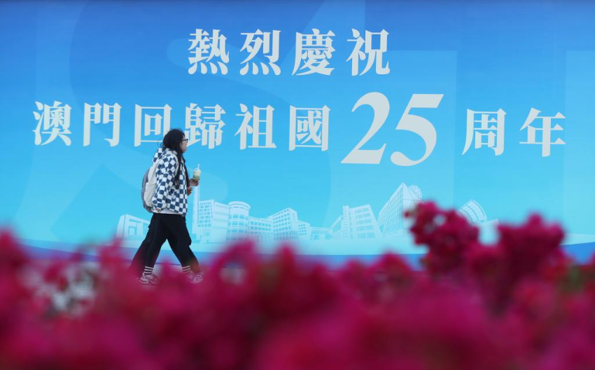 12月17日，行人经过澳门科技大学校园内的一处庆祝海报。