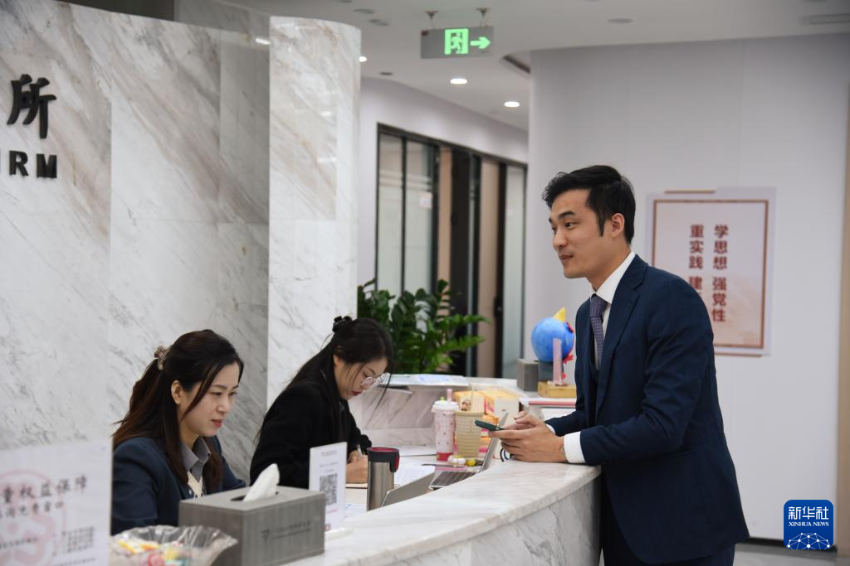 澳门律师阮嘉锐（右）在和同事交谈（12月19日摄）。