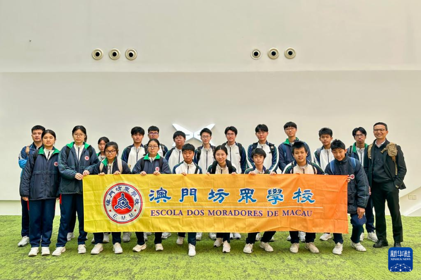 澳门坊众学校学生在小鹏汽车广州总部合影留念（3月21日摄）。