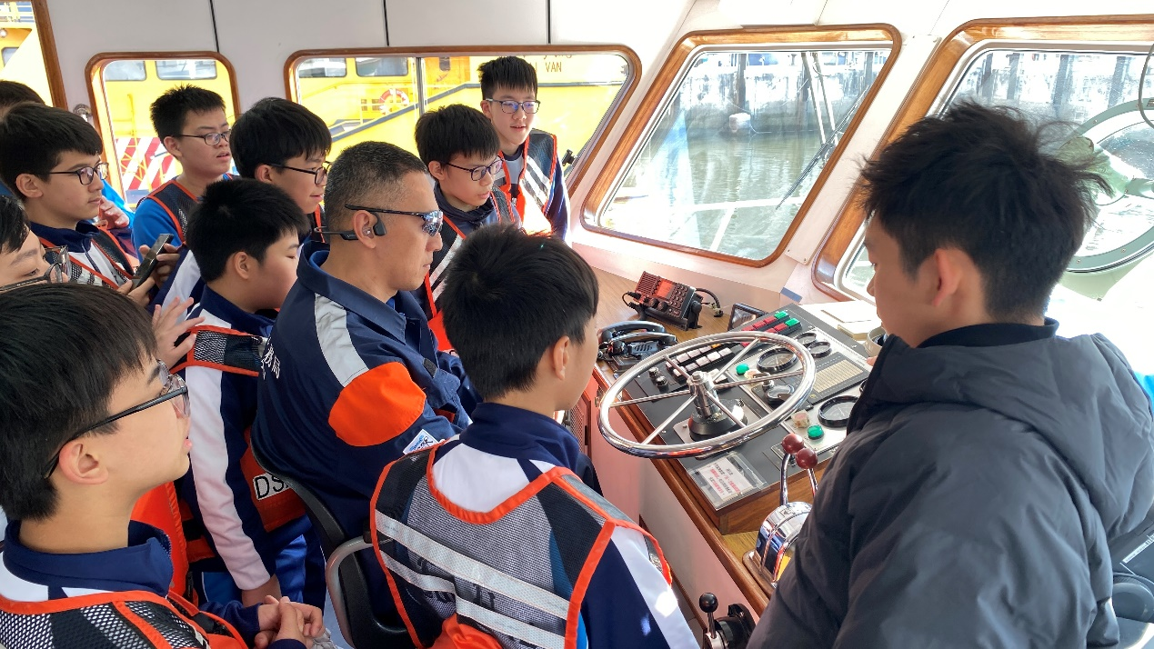 图为同学们走进驾驶舱近距离认识航海设备。