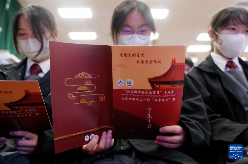 4月9日，在香港培侨中学，学生在“京港两地共上一堂国安课”活动上阅读学生手册。