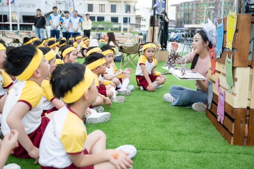 4月23日，澳门小朋友在户外阅读区听老师讲故事书。