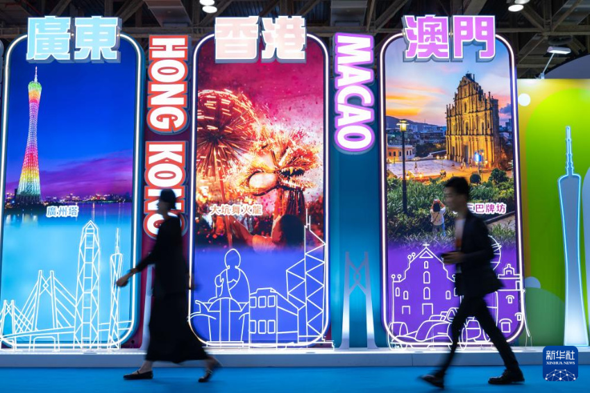 4月25日，参观者从第十三届澳门国际旅游（产业）博览会大湾区展板前经过。