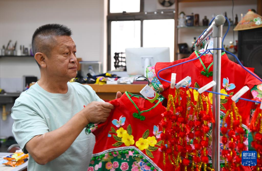 4月30日，飘色师傅李智伟在整理小演员的服饰。