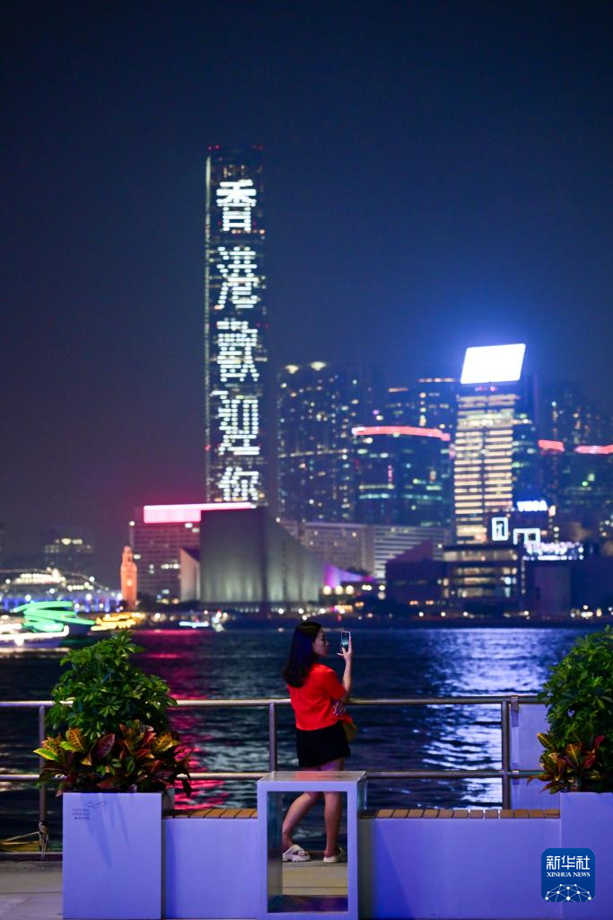 5月2日，一名女士在拍摄香港维多利亚港夜景。