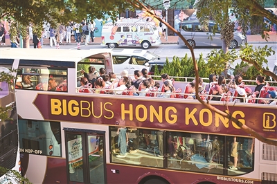 游客在香港乘坐观光巴士游览。