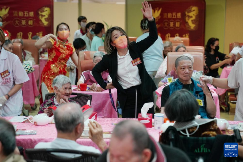 5月24日，在香港松悦园耆和护养院，安老事务委员会委员、香港乐龄社企“软餐侠”创办人文慧妍（中，穿黑色外套）带领职员扮演成“茶楼”经理、厨师和接待员，为老人家提供沉浸式茶楼就餐体验。