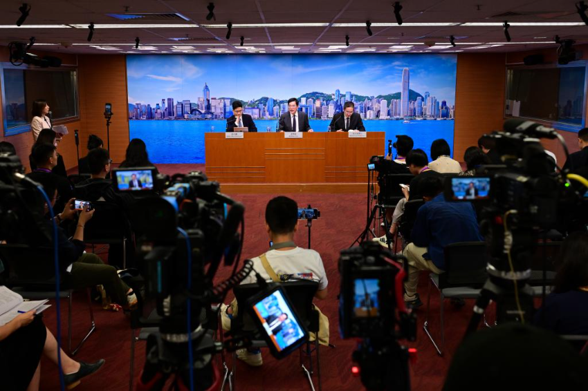 6月23日，香港特区政府署理财政司司长黄伟纶（中）等人士会见传媒。