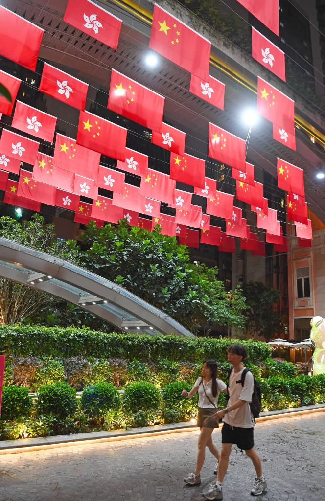 7月1日，行人从悬挂着五星红旗与特区区旗的香港利东街走过。