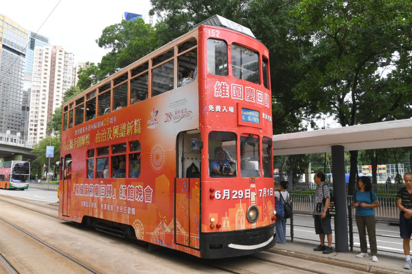 7月1日，一辆涂装庆祝香港回归祖国28周年海报的电车从香港街头驶过。