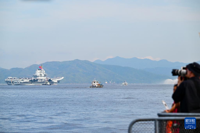 7月3日，人们在岸上拍摄海军山东舰抵达香港。