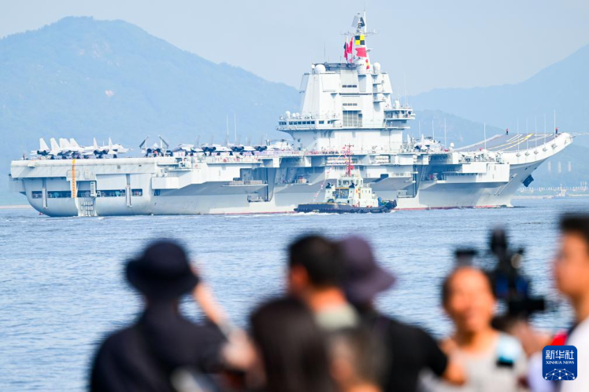 7月3日，人们在岸上拍摄海军山东舰抵达香港。