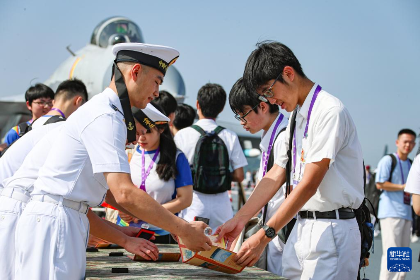 7月4日，锚泊在维多利亚港的山东舰对香港青少年学生开放。这是学生们在集章点打卡留念。