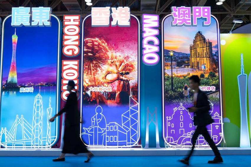 4月25日，参观者从第十三届澳门国际旅游（产业）博览会大湾区展板前经过。