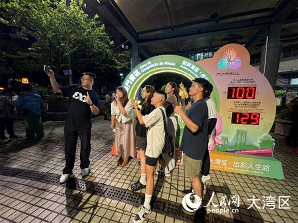 图为澳门居民与全运会倒计时牌合影留念。