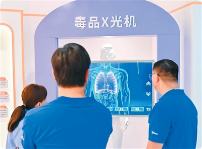 交流团成员在体验模拟毒品X光机操作。